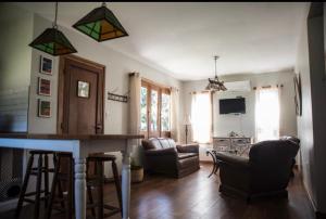 a living room with a bar with chairs and a couch at Chacra Los Arándanos in Durazno