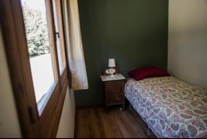 um pequeno quarto com uma cama e uma janela em Chacra Los Arándanos em Durazno