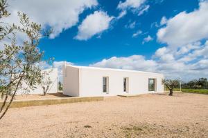 un edificio blanco con un cielo azul en el fondo en Casa do Roxo - Eco Design Country House, en Santa Vitória