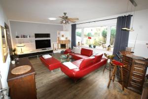 a living room with red furniture and a large window at Ferienhaus Landhaus Klein in Erbach im Odenwald