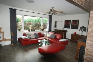 a living room with a red couch and a table at Ferienhaus Landhaus Klein in Erbach im Odenwald
