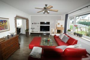 a living room with a red couch and a table at Ferienhaus Landhaus Klein in Erbach im Odenwald