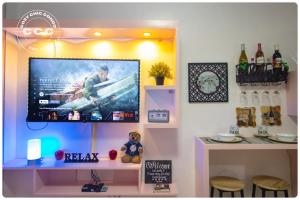 Zimmer mit einem TV an der Wand in der Unterkunft Cozy Chic Condotel Avida Towers Sucat in Manila