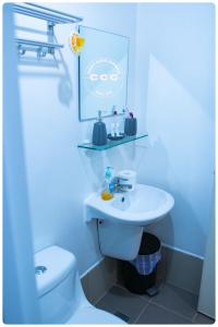 ein Badezimmer mit weißer Toilette und Waschbecken in der Unterkunft Cozy Chic Condotel Avida Towers Sucat in Manila