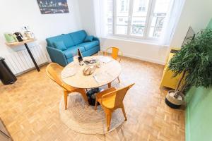 a living room with a table and chairs and a blue couch at Le Station Angers - Gare - Hypercentre in Angers