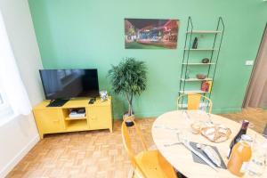 uma sala de estar com uma mesa e uma televisão em Le Station Angers - Gare - Hypercentre em Angers