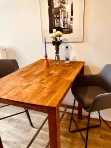 a wooden table with a vase of flowers and a candle at Zentrales und ruhiges Apartment im beliebtesten Bremer Viertel in Bremen