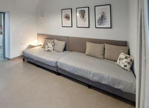 a couch in a living room with pictures on the wall at Harmony Cottage in Vasilikí