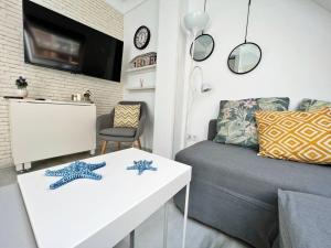 una sala de estar con un sofá y una mesa en Coqueto ático de playa, en Fuengirola