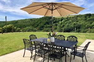 a black table and chairs with an umbrella at Barton Rock in West Down
