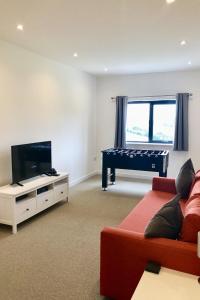 a living room with a tv and a couch and a table at Barton Rock in West Down