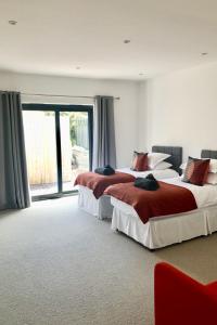 a bedroom with two beds and a large window at Barton Rock in West Down