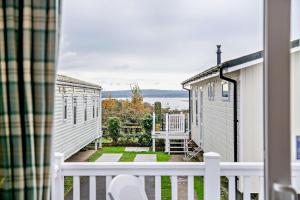 a view from the balcony of a house with a white fence at Sea La Vie Lodge, Rockley Park Holiday Park, Poole, Dorset in Poole