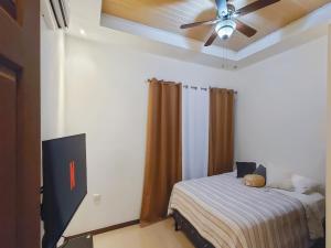een slaapkamer met een bed en een plafondventilator bij Apartment Equipped With Excellent Location in Liberia