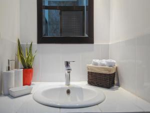 lavabo blanco en el baño con espejo en Apartment Equipped With Excellent Location en Liberia