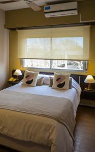 a bedroom with a large white bed with a window at Hotel San Carlos in General Juan Madariaga