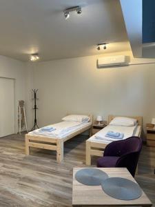 a room with two beds and a couch and a table at Etna 4 - Apartamenty -Parking Osmeckiego 4 E Rzeszów -Parking -Garaż- in Rzeszów