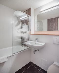 a white bathroom with a sink and a mirror at Hotel Restaurant l'Eskemm St Brieuc-Trégueux in Tregueux