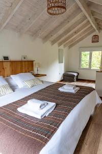 - une chambre avec 2 lits et des serviettes dans l'établissement Happy Host-Casas Cruz del Sur, à Villa La Angostura