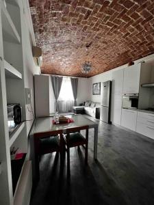 ein Wohnzimmer mit Tisch und Küche in der Unterkunft Casa Gabu in Turin