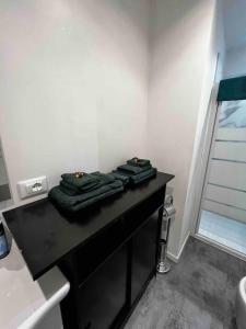 ein Bad mit einer schwarzen Theke und Handtüchern darauf in der Unterkunft Casa Gabu in Turin
