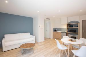 een woonkamer met een witte bank en een tafel en stoelen bij LOGIS LES CEPAGES / RESTAURANT LE RAISIN in Pont-de-Vaux +21 foto's