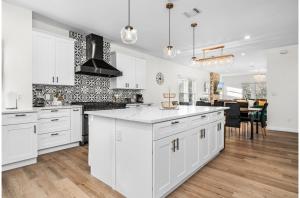 a kitchen with white cabinets and a dining room at Bold Bright 4BR3.5FULL BATHS Near Riverwalk Dtown in San Antonio