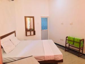 a bedroom with a bed and a mirror and a chair at Abi Resort in Galle