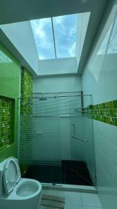ein Bad mit einer Glasdusche und einem WC in der Unterkunft Cozy Villa Tai in Na Jomtien