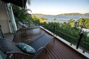 balcón con banco y vistas al agua en Suítes com Vista Espetacular da Lagoa da Conceição, en Florianópolis