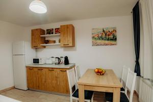 kuchnia z drewnianym stołem oraz kuchnia ze stołem i lodówką w obiekcie City Centre House w Sybinie