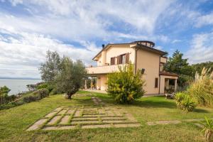 a house on a hill next to the ocean at Villa il Mandorlo by VacaVilla in Passignano sul Trasimeno