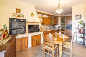 a kitchen with a wooden table and a stove at Villa il Mandorlo by VacaVilla in Passignano sul Trasimeno