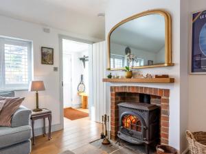 a living room with a fireplace and a mirror at 3 bed property in Stonegate Sussex 57396 in Ticehurst