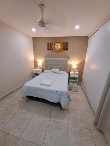 1 dormitorio con 1 cama y reloj en la pared en ALOJAMIENTO NORTE SGO en Santiago del Estero