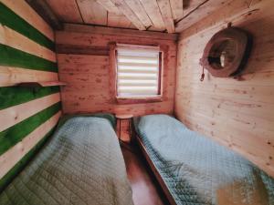Habitación pequeña con 2 camas en una cabaña en Domki drewniane pod Karpaczem 9 osobowy, en Mysłakowice