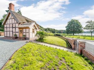 an old house with a green lawn in front of it at 2 bed in Whitchurch 79135 in Hanmer