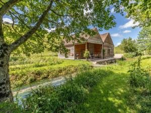 una cabaña de madera en un campo con un río en 2 bed in Dorchester 75243 en Frampton