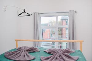 Schlafzimmer mit einem Bett und einem Fenster in der Unterkunft Modern Manor Loft in Liverpool