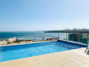 a swimming pool on top of a building next to the ocean at Three Bedroom at Nyali in Mombasa