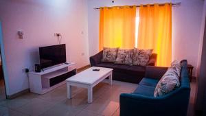 Una sala de estar con un sofá y un televisor. en Three Bedroom at Nyali, en Mombasa