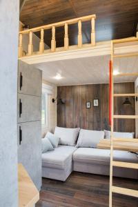 a living room with a couch and a loft bed at Tiny House Flexhome in Buchenberg