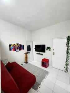 a living room with a red couch and a tv at Lindo, fofo e aconchegante in Rio de Janeiro