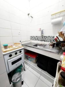 a small kitchen with a sink and a stove at Lindo, fofo e aconchegante in Rio de Janeiro