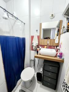 a bathroom with a toilet and a sink and a mirror at Lindo, fofo e aconchegante in Rio de Janeiro