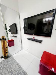 a living room with a flat screen tv on a wall at Lindo, fofo e aconchegante in Rio de Janeiro