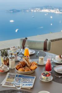 a table with a breakfast of pastries and orange juice at La Chèvre d'Or in Éze