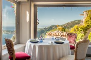a table with a view of the ocean from a window at La Chèvre d'Or in Éze