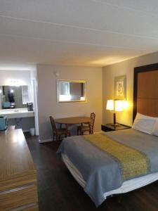 a hotel room with a bed and a table at APM Inn and Suites in Winchester