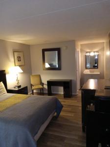 a hotel room with a bed and a desk at APM Inn and Suites in Winchester